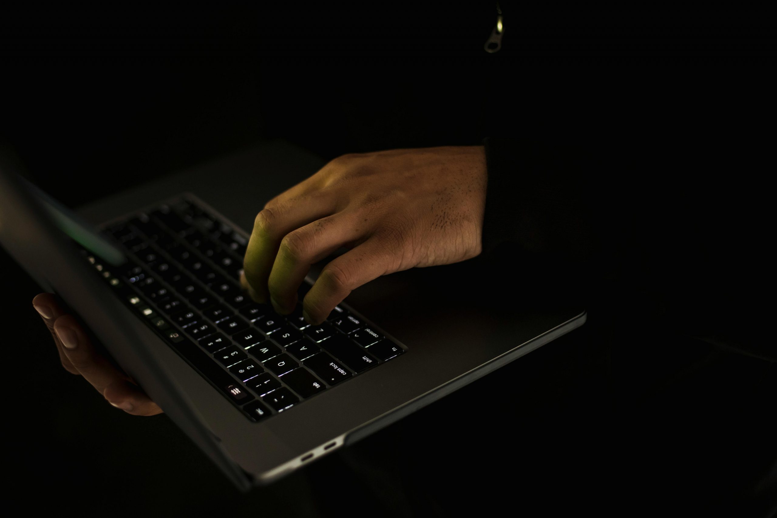 Ernte Gesichtslosen Mann, Der Auf Laptop Tastatur In Der Dunkelheit Tippt